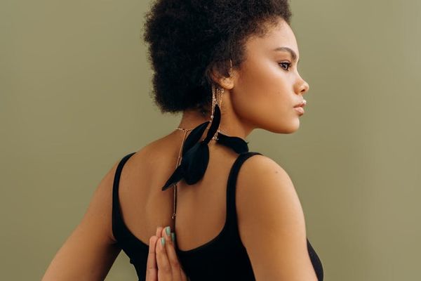 A person in a focused yoga posture inside a modern, spacious studio with soft lighting.